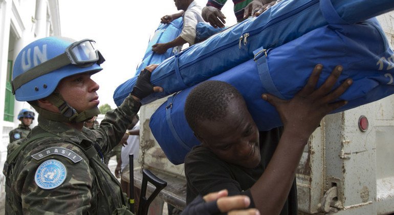 Brazilian United Nations peacekeepers distribute tarps and tents in down town Port au Prince Haiti.