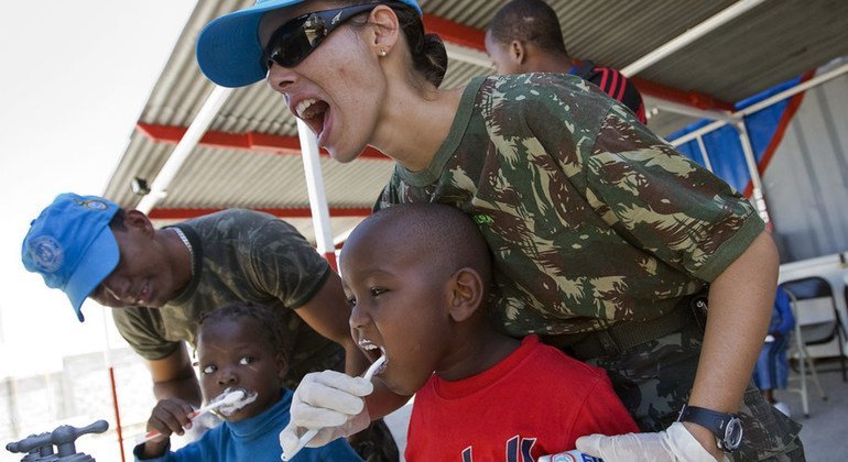 Los miembros del batallón brasileño de la Misión de Estabilización de las Naciones Unidas en Haití (MINUSTAH) enseñan a un grupo de niños locales la atención dental adecuada.