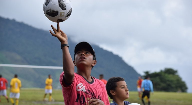 Los niños ven cómo varios excombatientes de las FARC-EP, antiguos paramilitares, miembros de las fuerzas de seguridad, artesanos y jugadores profesionales jugaron un amistoso con la comunidad local de Llano Grande, en el departamento de Antioquia.