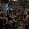 Una mujer ayuda a sus hijos a alistarse para dormir en Bangladesh.