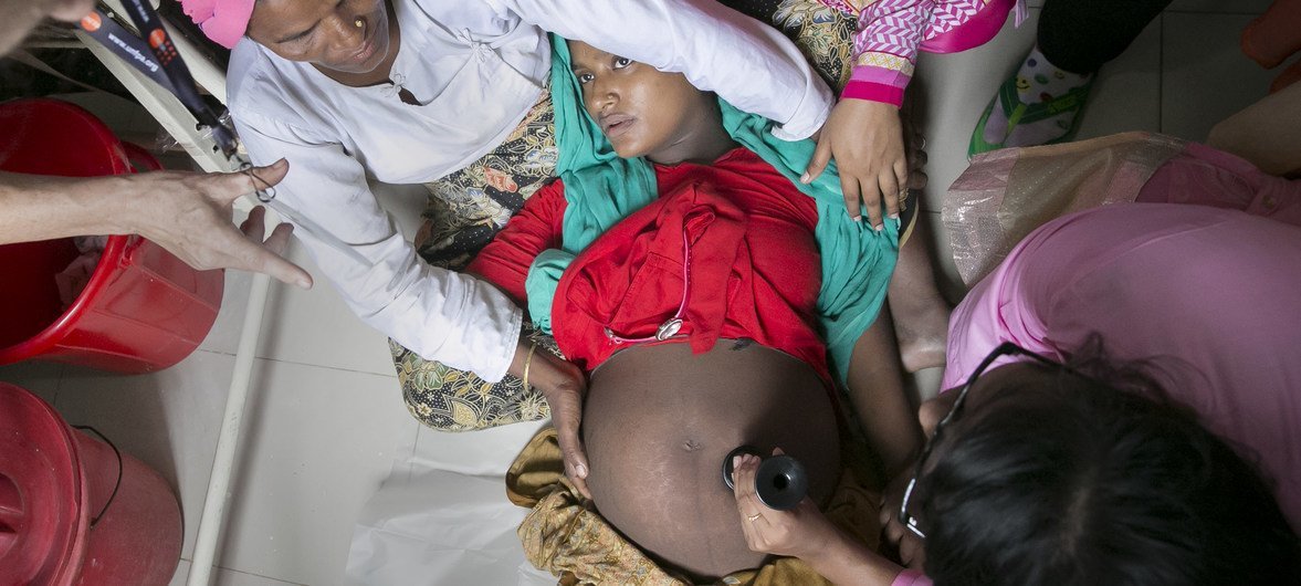 Health workers rush to assist a pregnant woman at the Nayapara refugee camp maternity centre.