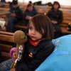A young child holds a toy as she seeks shelter with other Afghan refugees from very cold, wet weather conditions at the Tabanovce reception centre for refugees in the former Yugoslav Republic of Macedonia after being refused entry into Serbia. February 20