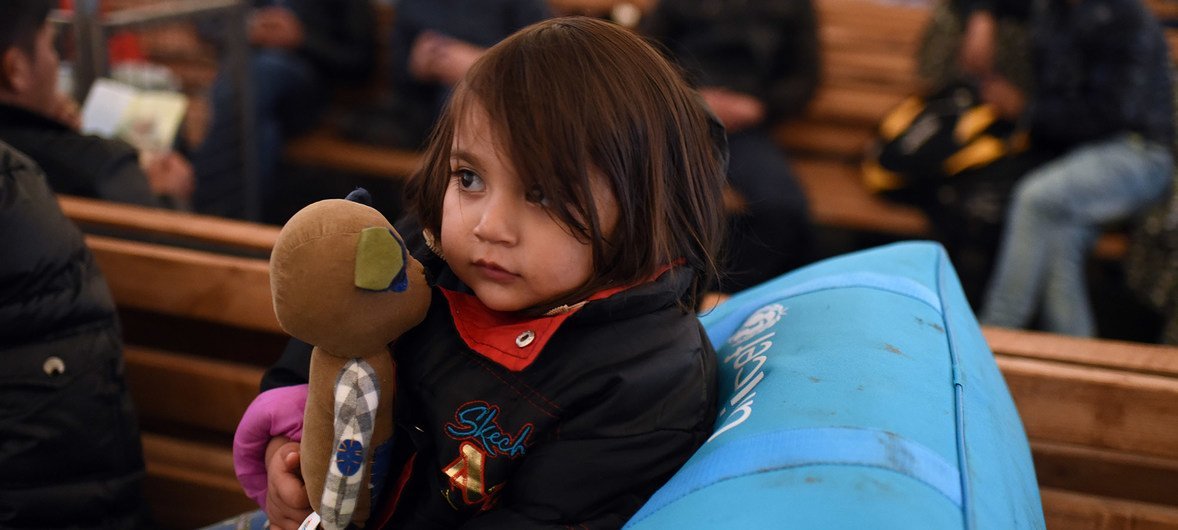 A young child holds a toy as she seeks shelter with other Afghan refugees from very cold, wet weather conditions at the Tabanovce reception centre for refugees in the former Yugoslav Republic of Macedonia after being refused entry into Serbia. February 20