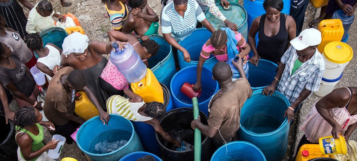 A Roseaux, en Haïti, des personnes affectées par l'ouragan Matthew en 2016 récupèrent de l'eau.