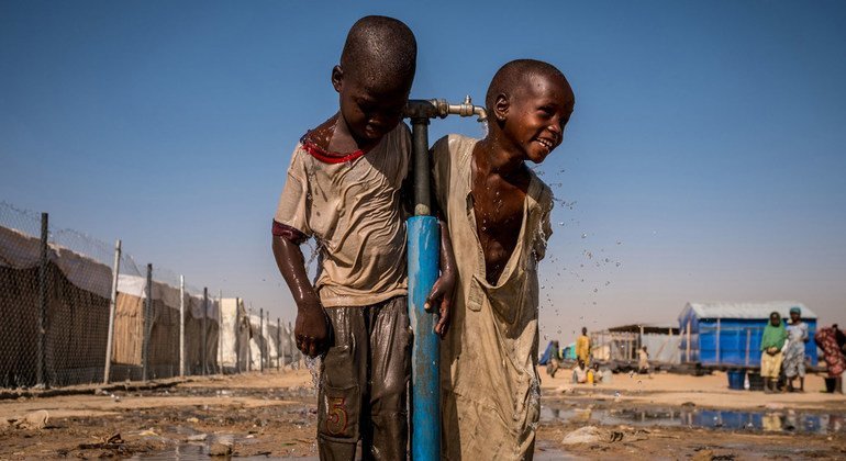 En la imagen, dos niños nigerianos juegan con una fuente de agua en el campamento para desplazados de Bukasi, en el estado de Borno.