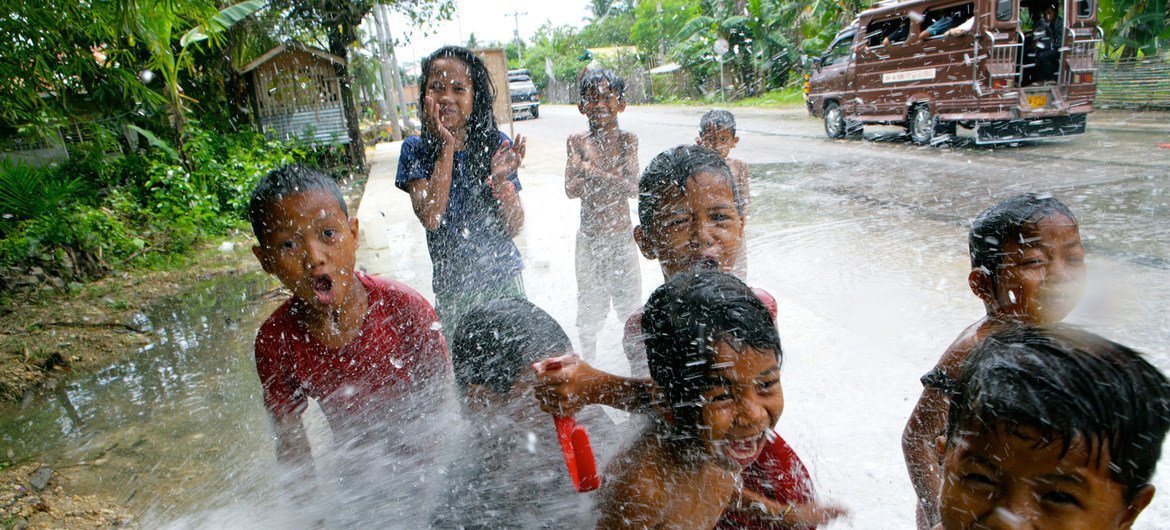 Des enfants jouent avec de l'eau dans la ville de Cotabato, sur l'île de Mindanao, aux Philippines.