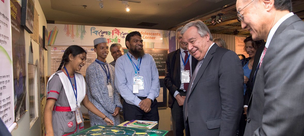 Secretário-geral António Guterres e o presidente do Grupo Banco Mundial, Jim Yong Kim, falam com crianças em uma exposição em Daca.