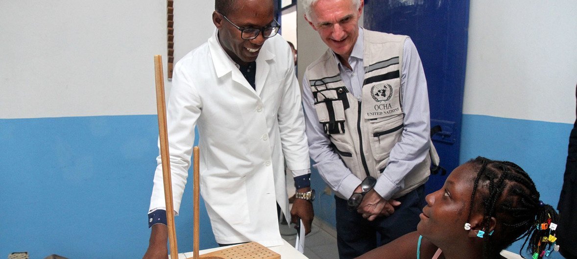 Mark Lowcock (center), Under-Secretary-General and Emergency Relief Coordinator (UNOCHA),meeting a patient at the Fondation Haitienne de Rehabilitation (FONHARE) in Fort Liberte, Haiti, with its president and physiotherapist, Dr. Ivens Louius (left) on 3 