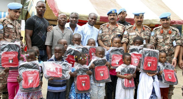 Cascos azules jordanos, con Operación de las Naciones Unidas en Côte d’Ivoire  (ONUCI), entregan útiles escolares a niños en Abiyán en octubre de 2013.  