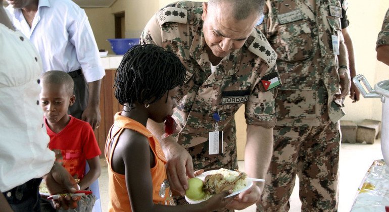 Fuerzas de la paz jordanas que ofrecen comida a estudiantes en Abiyán, Costa de Marfil. 