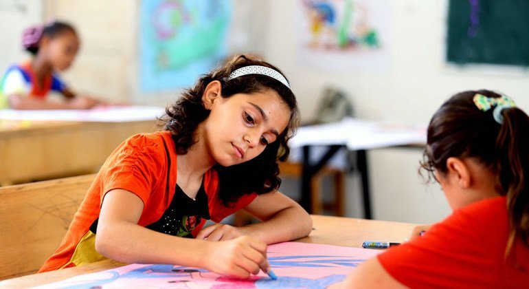 Una niñas colorean durante un campamento de verano en la escuela Deir Al Balah