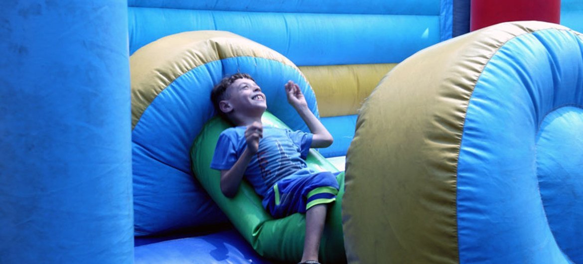 طفل يستمتع باللعب خلال فعاليات أسابيع المرح الصيفية في الاتحاد العام للأشخاص ذوي الإعاقة في خان يونس.