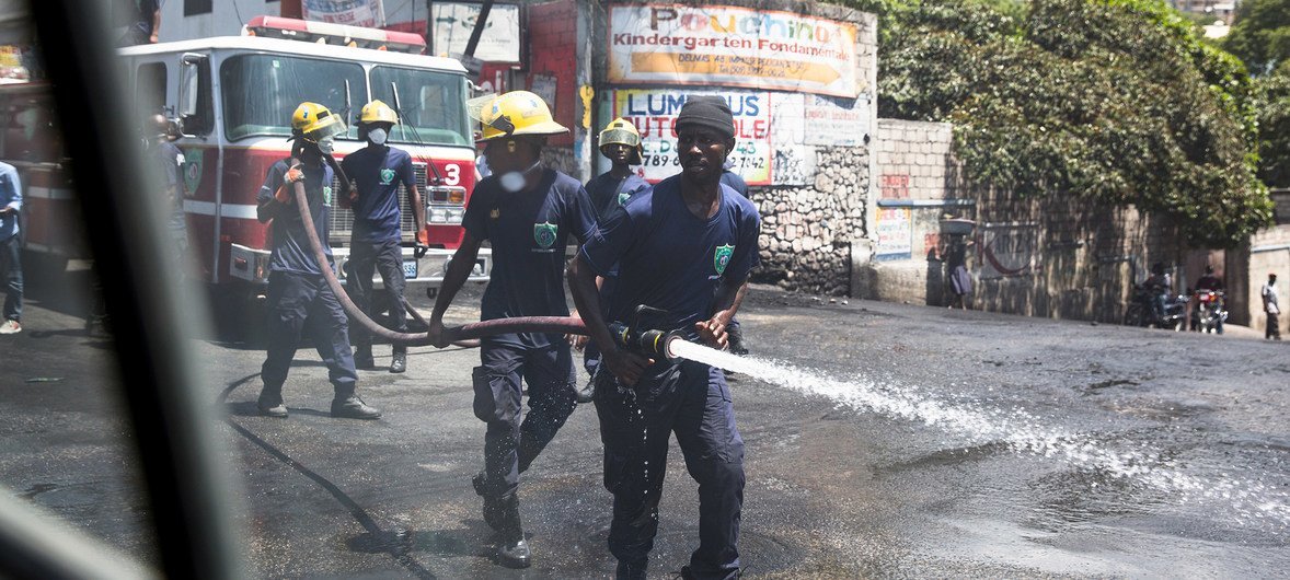 A brigade works to clean the streets in Port-au-Prince, Haiti, following three days of violent protests.