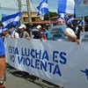 尼加拉瓜首都马那瓜，参加游行的民众手持写有“这是一场非暴力抗争”的横幅，要求终止暴力。