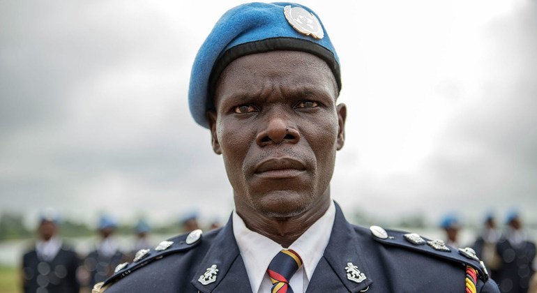 Afisa wa polisi wa Kenya anayehudumu katika mpango wa Umoja wa Mataifa nchini  Liberia (UNMIL) akiwa amesimama kwa ukakamavu kwa ajili ya wimbo wa taifa wakati wa sherehe ya kupokea tuzo kwenye kambi ya Clara, mjini Monrovia, mwezi May 2014.