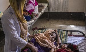 A midwife checks an exhausted new mother, who is recuperating next her 3-day-old sleeping infant daughter at the UNICEF-supported birthing centre in the Kutupalong camp for Rohingya refugees, in Cox’s Bazar, Bangladesh, October 2017.