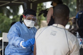 Le 20 juin 2018, un membre de l'OMS vaccine un homme contre le virus Ebola dans le village de Bosolo, en RDC