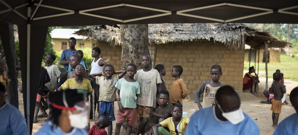 Un grupo de personas mira como vacunan contra el Ébola en el pueblo de Bosolo, República Democrática del Congo.