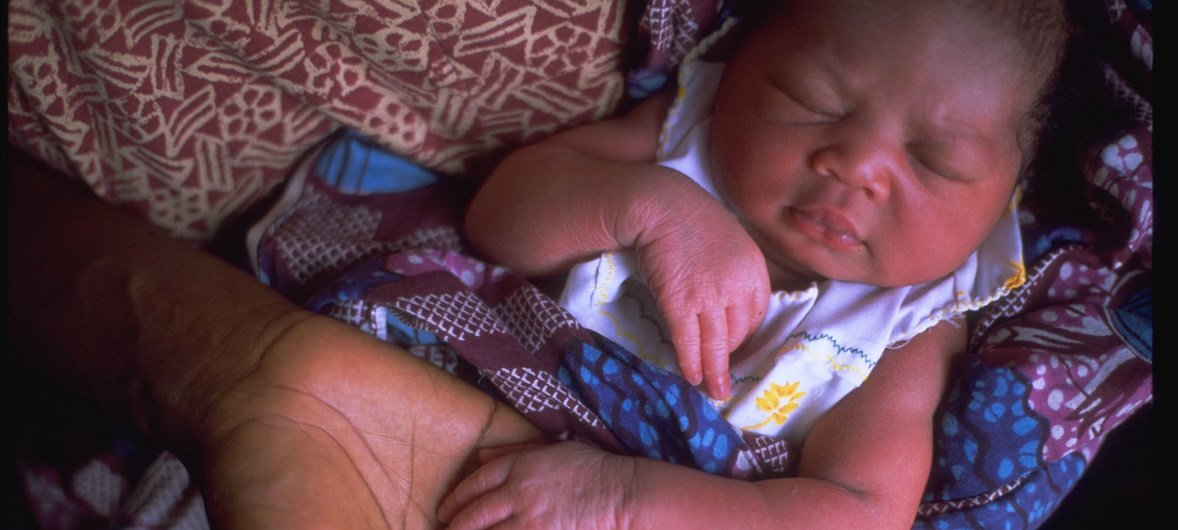 A newborn sleeps in his mother's arms, in a health centre in Accra, Ghana.