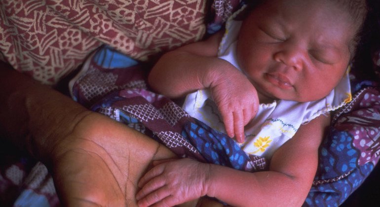 Un recién nacido duerme en los brazos de su madre en un centro de salud de Accra en Ghana.