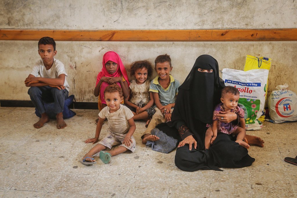 سيدة وأطفالها ينتظرون توزيع مساعدات طارئة مدعومة من اليونيسف في الحديدة، اليمن. يونيه حزيران 2018.