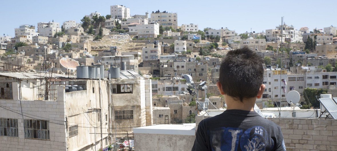 12 juillet 2018 : Hamid, 8 ans, regarde, depuis le toit de sa maison, la vieille ville d'Hébron. La circulation des personnes et l'accès à l'école des enfants sont affectés par les points de contrôle situés dans la vieille ville de Cisjordanie.