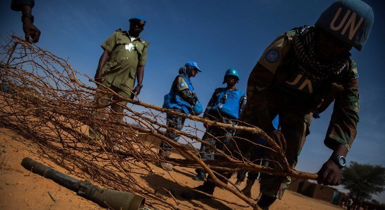 أحد جنود بعثة يوناميد يحاول وضع فرع شجرة في موقع قذيفة هاون تم اسقاطها خلال اشتباكات مسلحة بالقرب من مخيم العباسي للنازحين في مليط ، شمال دارفور. 