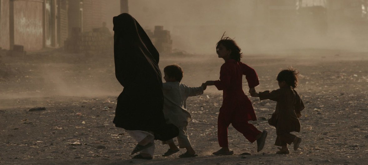 A family runs across a dusty street in Herat, Afghanistan. (file)