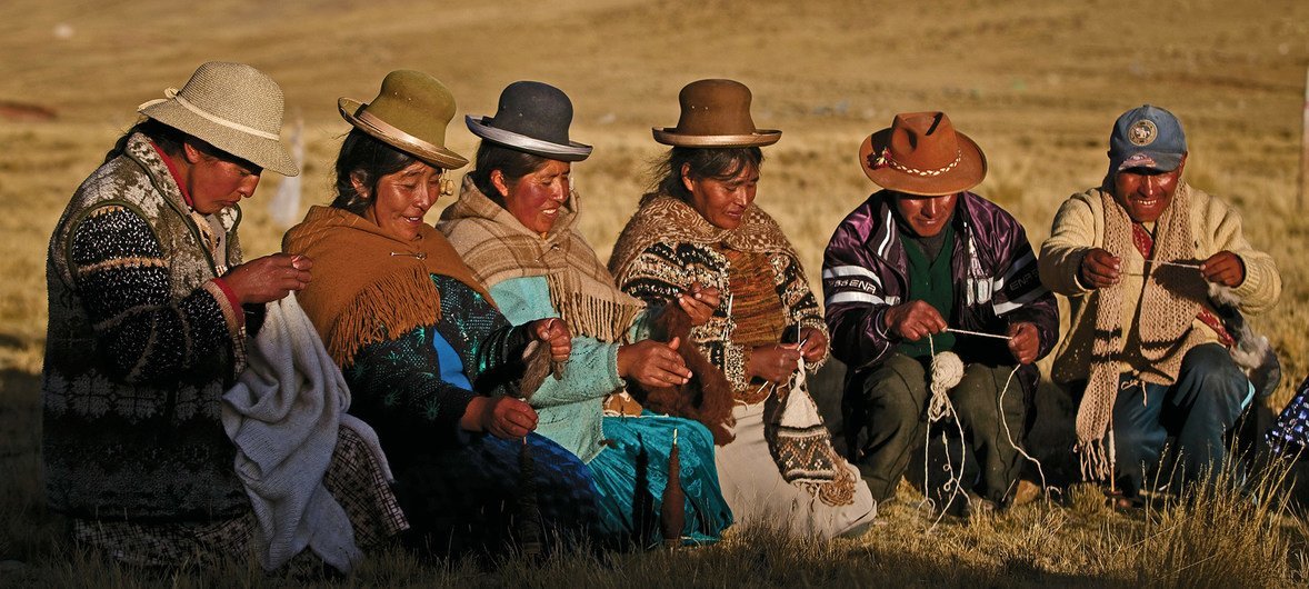 秘鲁南部的普诺（Puno），土著男性和妇女正在用羊驼毛编织服装。