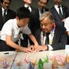 El Secretario General António Guterres dobla grullas de origami con jóvenes líderes japoneses en el Monumento a la Paz de Nagasaki.