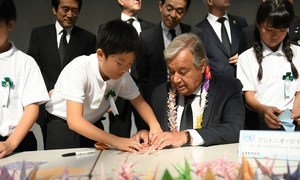 Secretary-General António Guterres folds origami cranes with young Japanese leaders at the Nagasaki Peace Memorial.