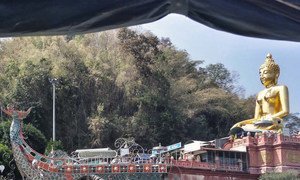 Statue of Buddha on a boat along the Mekong River bank in Chiang Rai, Thailand. Twelve youth football players and their coach were rescued alive in July 2018 after heavy seasonal flooding trapped them for over two weeks in the nearby Tham Luang caves.