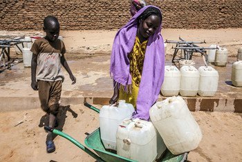 طفلة وأخاها في محطة للمياه بمعسكر أبو شوك للنازحين في شمال دارفور، يحاولان الحصول على بعض المياه، حيث يعاني النازحون شحا في مياه الشرب.