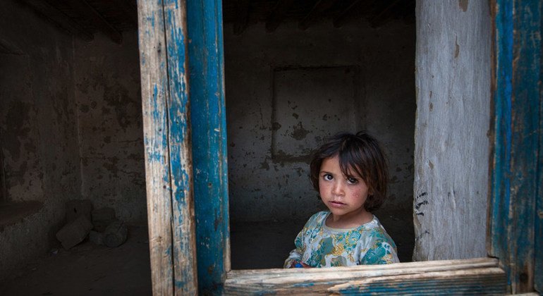 Una niña mira a través de una ventana sin cristales en Kabul, Afghanistán en 2013. Los civiles han soportado casi 20 años de guerra.