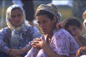 A boy rests against a woman in a camp of people displaced from Srebrenica, at the Tuzla airport in Bosnia and Herzegovina, 1995.