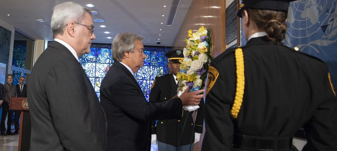 الأمين العام أنطونيو غوتيريش (وسط) يضع إكليلا من الزهورإحياء لذكرى من فقدوا أرواحهم في الهجوم الإرهابي على الأمم المتحدة في العراق.