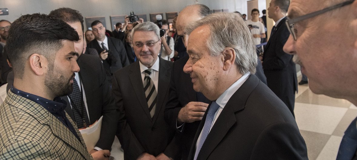 Secretary-General António Guterres speaks to terror victim Sayad Mushtaq Hussaini (left) at a multimedia exhibition to mark the first International Day of Remembrance of and Tribute to Victims of Terrorism, NY, August 2018.
