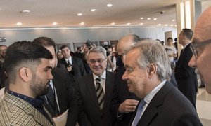 Secretary-General António Guterres speaks to terror victim Sayad Mushtaq Hussaini (left) at a multimedia exhibition to mark the first International Day of Remembrance of and Tribute to Victims of Terrorism, NY, August 2018.