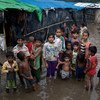 Des enfants réfugiés rohingyas les pieds dans l'eau devant les abris de leurs familles suite à une violente tempête de pré-mousson dans le camp de fortune de Shamlapur à Cox's Bazar, au Bangladesh.