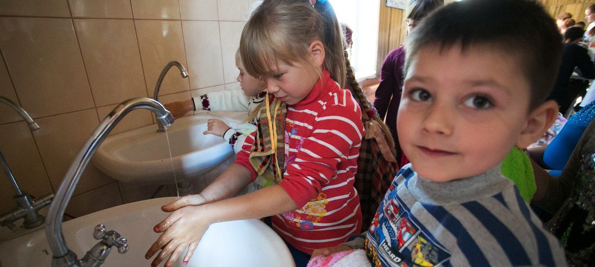 Crianças lavam as mãos em Toretsk, na Ucrânia. 