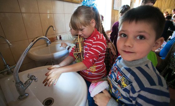Crianças lavam as mãos em Toretsk, na Ucrânia. 