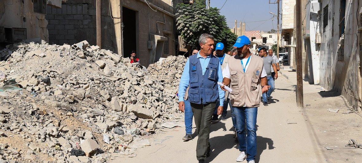 UN High Commissioner for Refugees Filippo Grandi (l) walks through the battle-scarred streets of Douma, in Syria's Eastern Ghouta suburb.