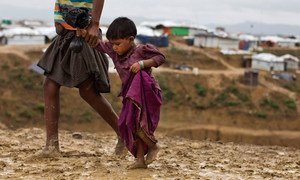 Two-year-old Rumana is led by a community worker as she and her family are relocated to a safer area of the Kutupalong-Balukhali camp, part of the refugee camp sheltering over 800,000 Rohingya refugees, Cox's Bazar, Bangladesh.