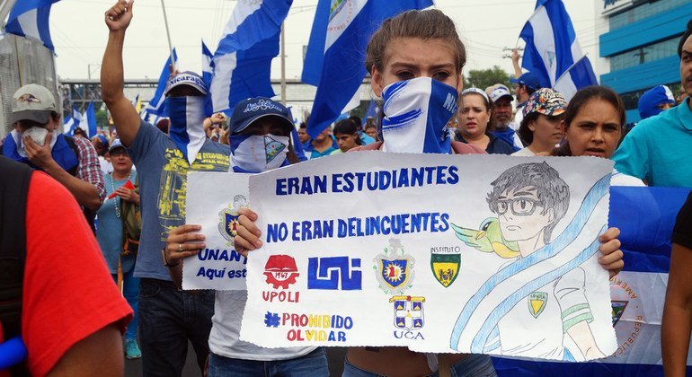 Manifestante na Nicarágua segura cartaz dizendo "eles eram estudantes, não criminosos"