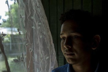 Victor Fernando, 17 ans, se tient près de la fenêtre de son domicile de Villanueva, au Honduras. Il a été victime d'intimidation à l'école concernant son orientation sexuelle. Depuis que l'intimidation a commencé, ses notes ont chuté.
