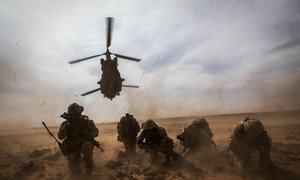 Un hélicoptère canadien CH-147 Chinook décolle alors que les Casques bleus canadiens de la MINUSMA se protègent de la poussière lors d'un exercice d'évacuation médicale près de Gao au Mali.