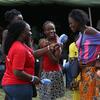 Uma mulher de camisa vermelha entrevista uma jovem com um microfone em um evento ao ar livre organizado pela Guira-FM, uma estação de rádio da ONU que promove a paz e a reconciliação na República Centro-Africana.