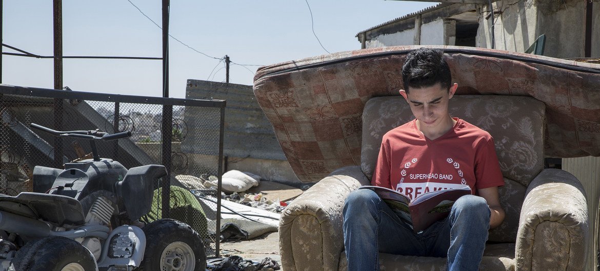 巴勒斯坦约旦河西岸的希伯伦，14岁的马尔万坐在自家屋顶上温习功课。