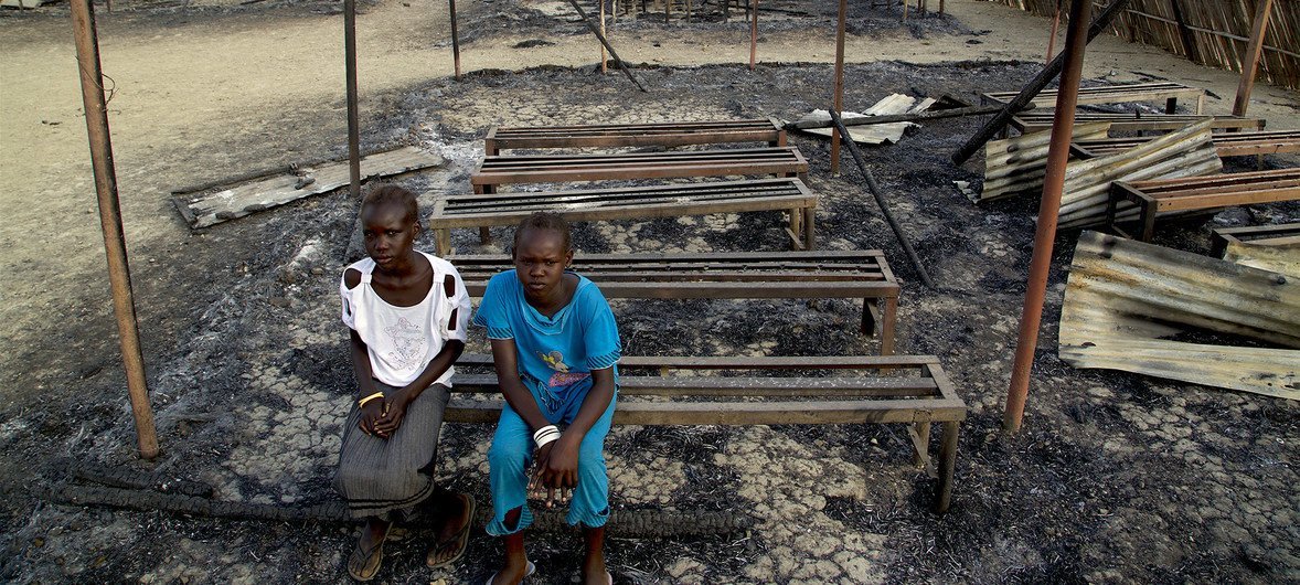 Chubat (à droite), 12 ans, est assise avec son amie au milieu des ruines de leur école incendiée à Malakal, au Soudan du Sud (3 mars 2016)