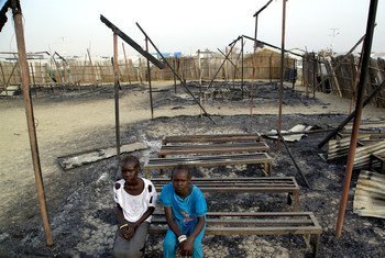 On 3 March 2016, Chubat (right), 12, sits with her friend in the burned ruins of her school in Malakal, South Sudan.
